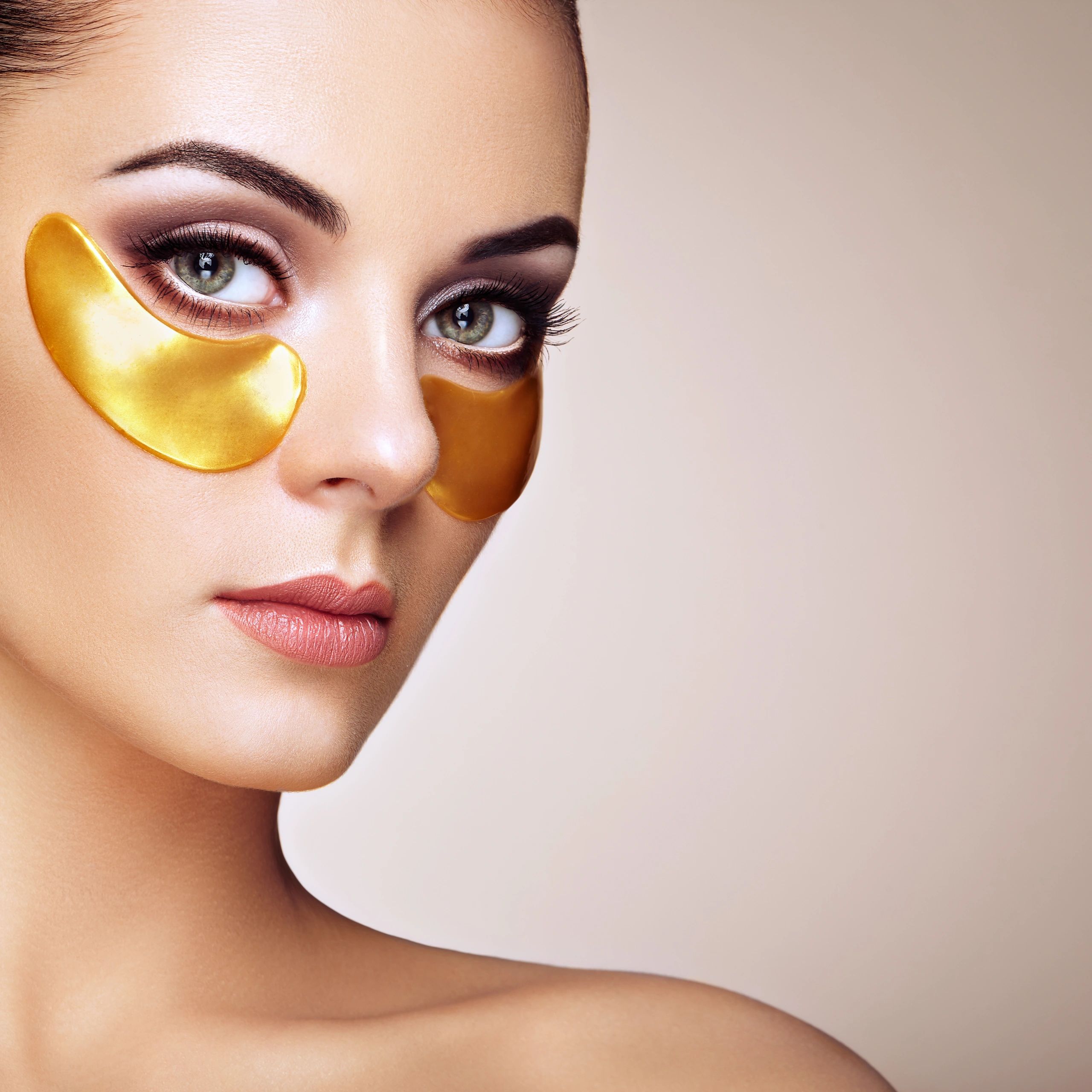 Beauty treatment close-up with gold eye patches and glowing skin