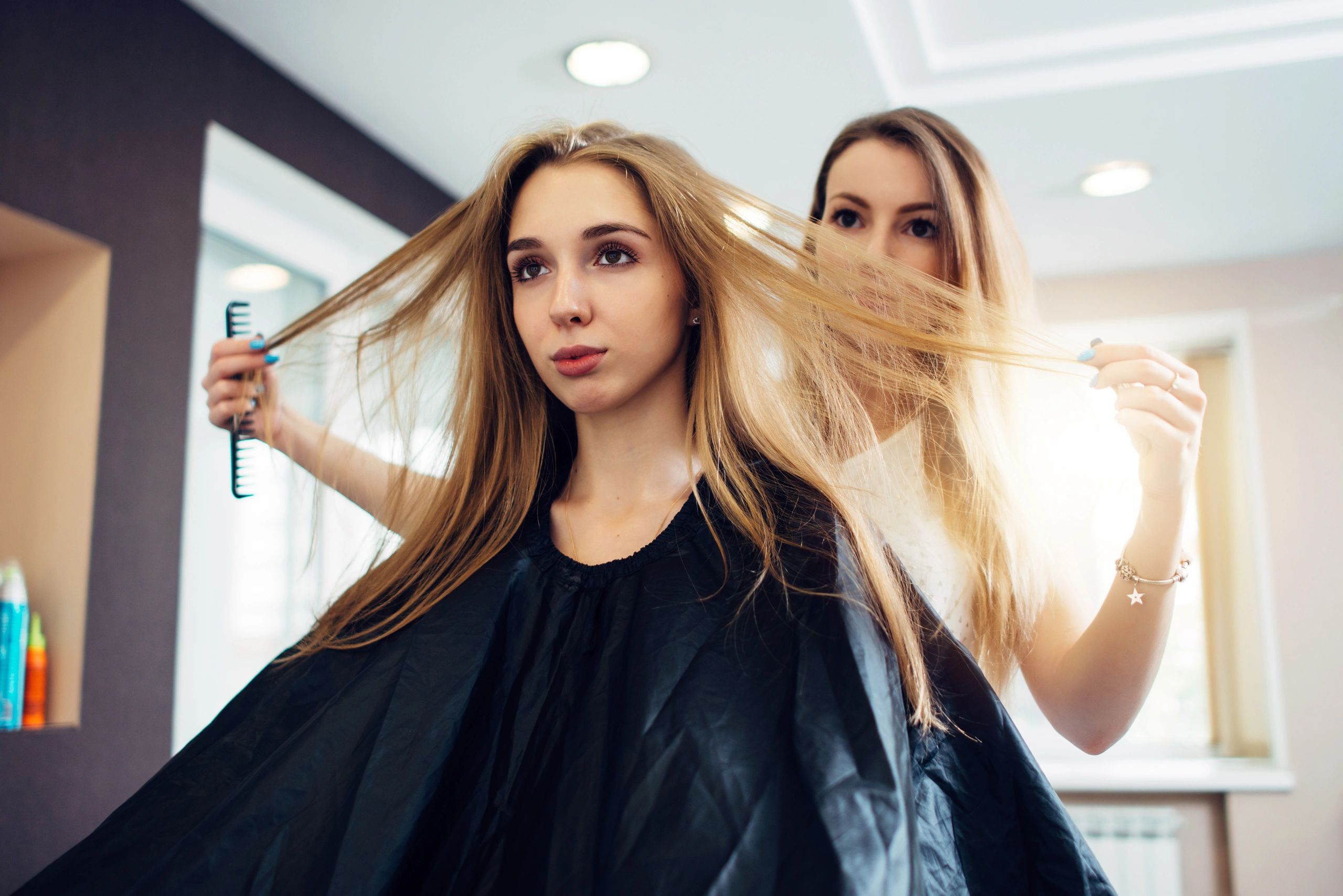 Stylist consulting with a salon client during a hair appointment
